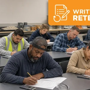Diverse group of aggregate testing technician candidates taking a Level 1 written exam in a classroom with sieves, aggregate samples, calculators, and safety glasses nearby.