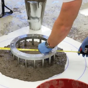 Concrete quality technician measuring fresh concrete during a laboratory test for quality control and assurance.