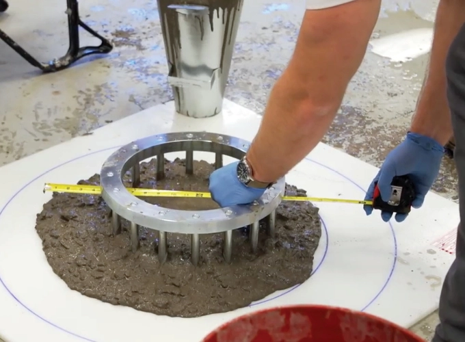 Concrete quality technician measuring fresh concrete during a laboratory test for quality control and assurance.